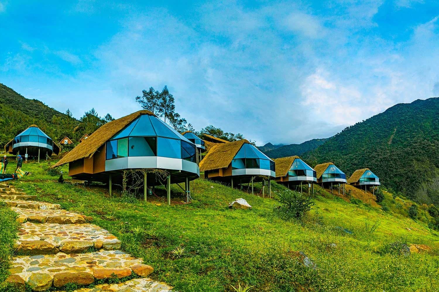 Thatched roofs, glass walls, and a hill all to yourselves, camping this is not. Photo: Mountain Sky View Collpapampa A row of unique stilt cabins with thatched roofs and panoramic glass walls lines a green Andean hillside on the salkantay trek to machu picchu, connected by a stone cobblestone path with mountain ridges behind