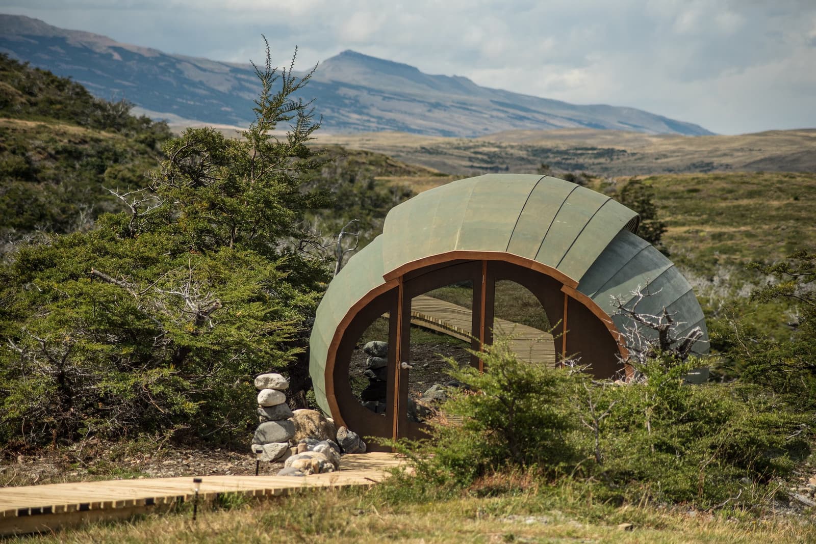 A hospedagem que faz você querer chegar ao acampamento logo. Photo: Massage Room Uma acomodação em forma de concha verde instalada entre arbustos nativos patagônicos e árvores lenga no trek W de Torres del Paine, com campos abertos e montanhas ao fundo