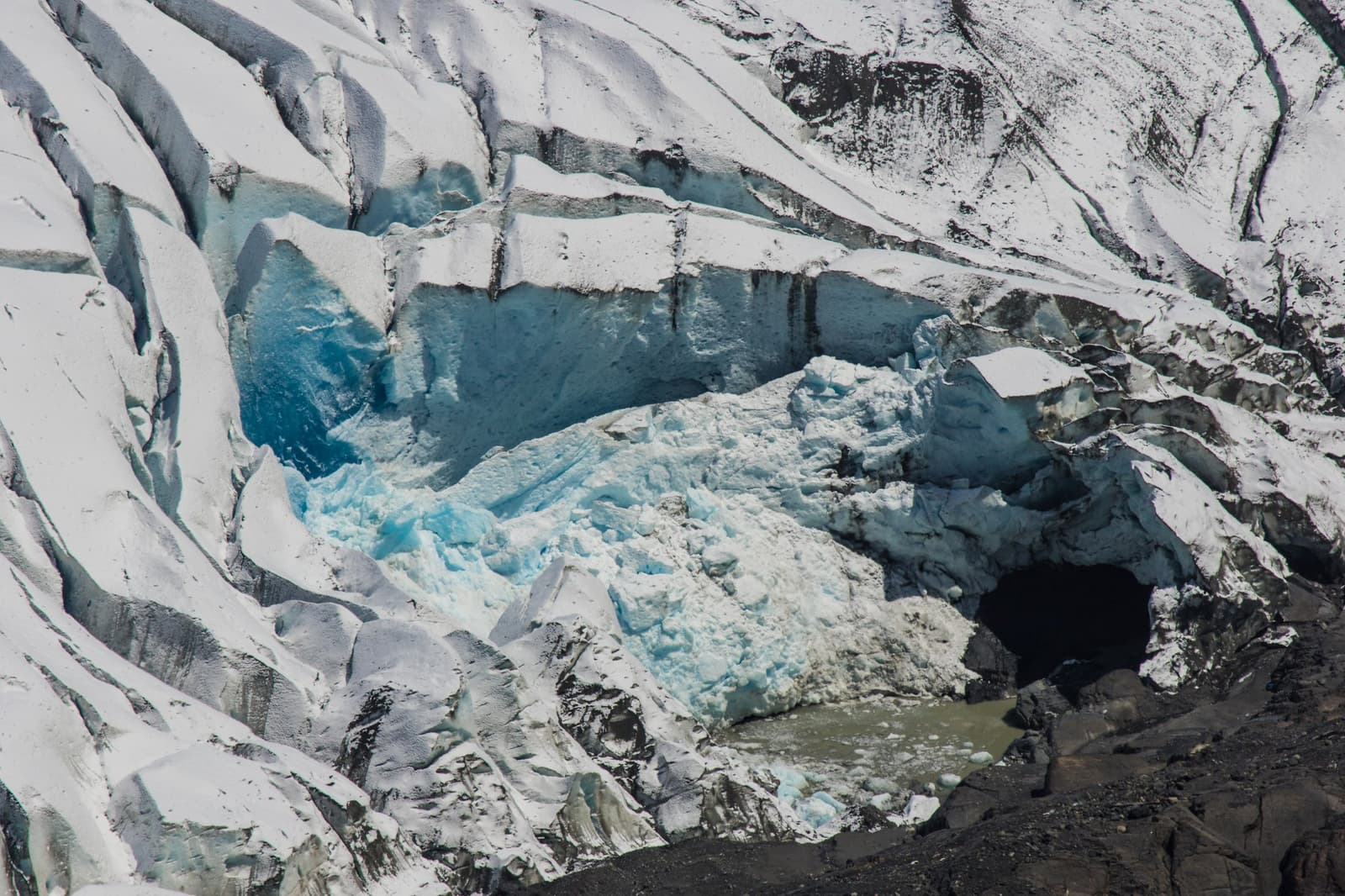 Blue this deep took thousands of years to make. Worth every uphill step. Photo: outdoorstv.cl A deep crevasse in a glacier reveals layers of compressed blue ice and a dark meltwater cave at its base, seen on the self-guided W Trek near Grey Glacier in Chilean Patagonia