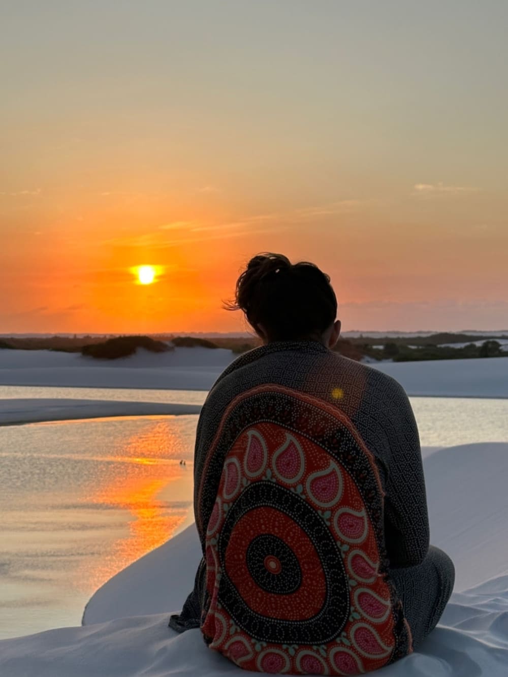 Femme debout au coucher du soleil dans les dunes pendant la randonnée dans les Lençóis Maranhenses, à Atins