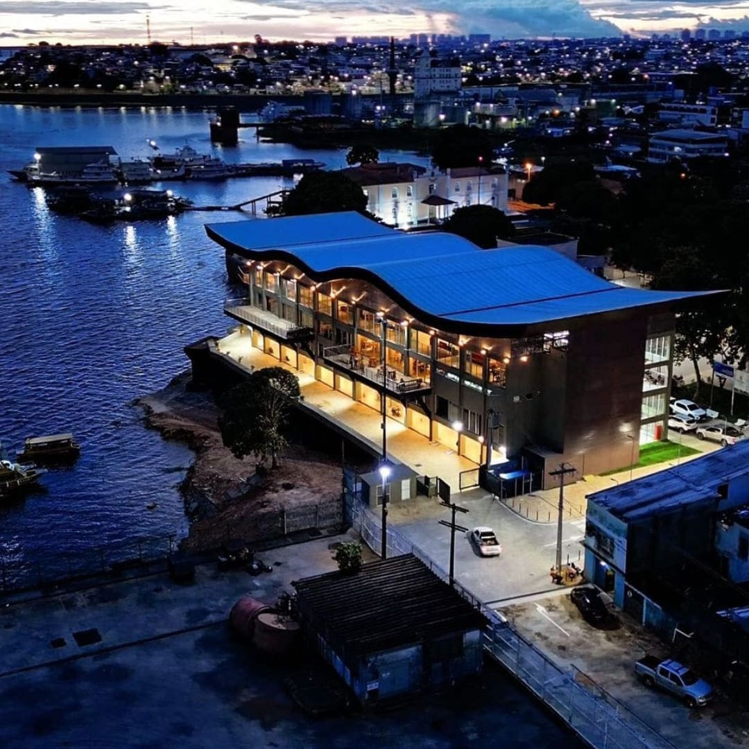 Nachtzicht van het verlichte Lúcia Almeida uitkijkpunt weerspiegeld in het rivierwater in Manaus.