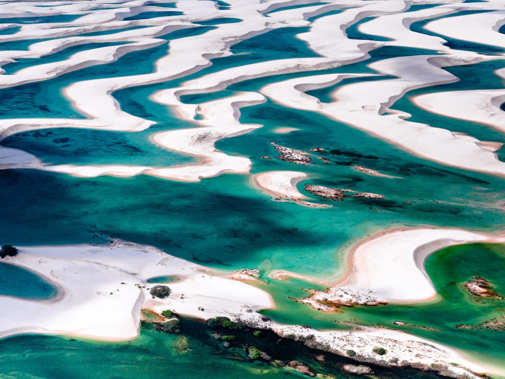 Vue aérienne des dunes de sable blanc et des lagunes verdoyantes d'eau de pluie du parc national des Lençóis Maranhenses.