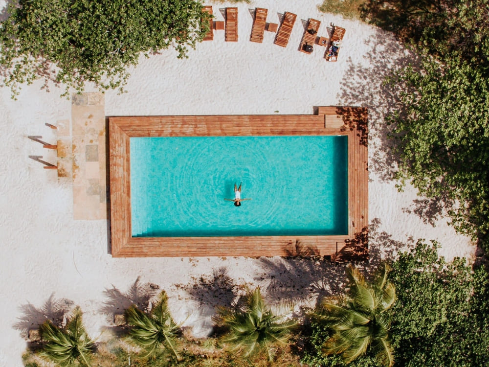 Luchtfoto van een persoon die zwemt in een rechthoekig zwembad bij herberg La Ferme de Georges.