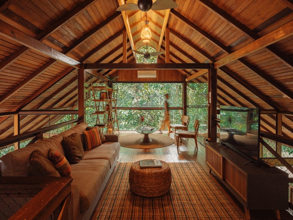 Een gezellig, rustiek interieur van een houten bungalow in een Amazone-ecolodge met een comfortabele woonruimte en uitzicht op het bos.